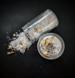 White bath salts with lavender and jasmine buds pictured in a corked jar