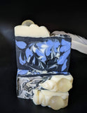 Black soap with periwinkle and white swirls with white ruffle and sparkling soap ball on top