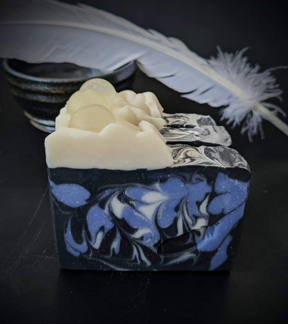 Black soap with periwinkle and white swirls with white ruffle and sparkling soap ball on top