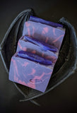 purple soap bar with fuchsia swirls and a purple soap crystals on top with holo glitter